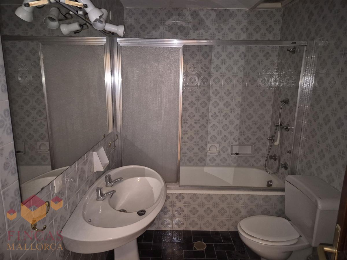 Bano antes del home staging en Arago Baño antes, con alicatado estampado, espejo y escasa iluminación