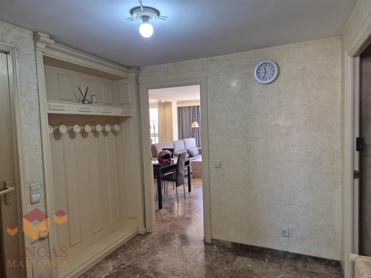 Recibidor antes del home staging en Arago Recibidor antes, con paredes en tonos crema, perchero y bombilla vista