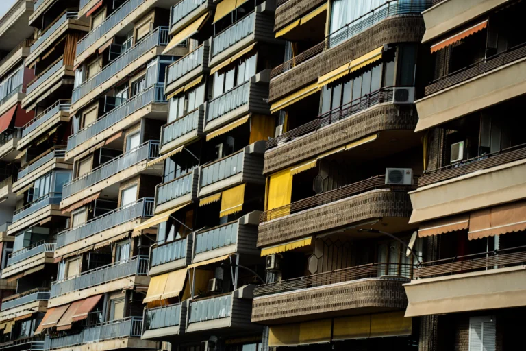 Registro y Catastro: fachada de un edificio de pisos con balcones y equipos de aire acondicionado