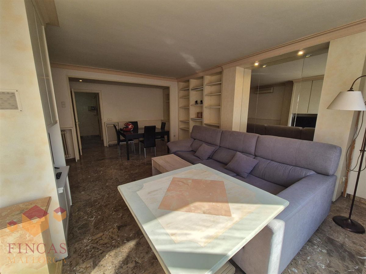 Salon antes del home staging en Arago Salón antes del home staging, ocupado por sofá y mesas, con acabados en tonos crema