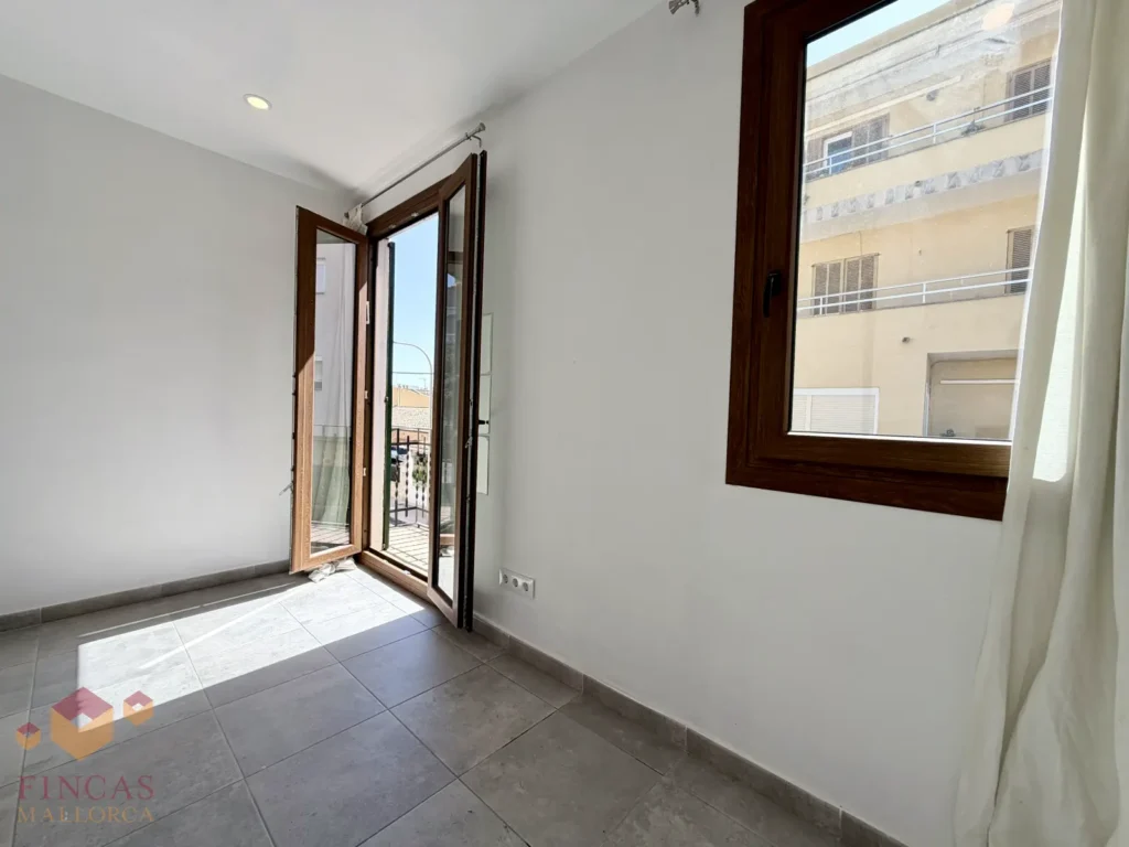 piso venta JOSEP MELIA palma42 Dormitorio principal con ventana y salida al balcón del piso en venta en L’Olivera, Palma